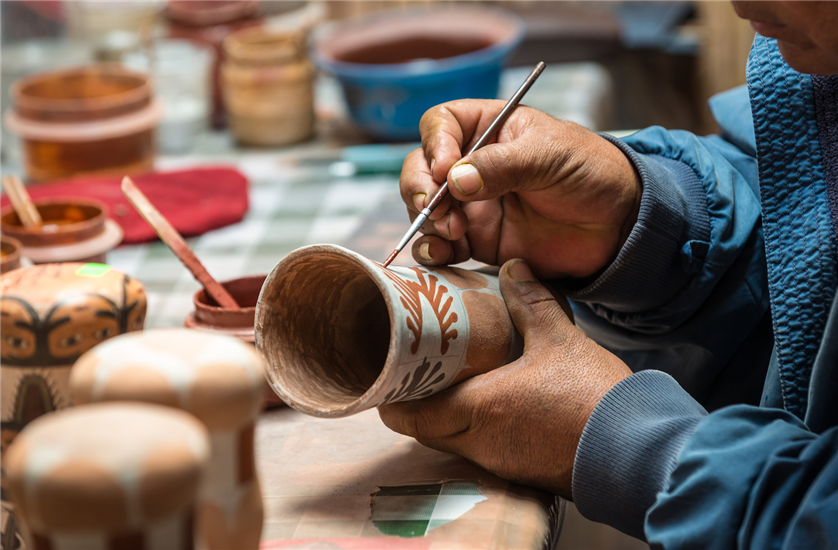 Painting pottery by hand in a pottery studio